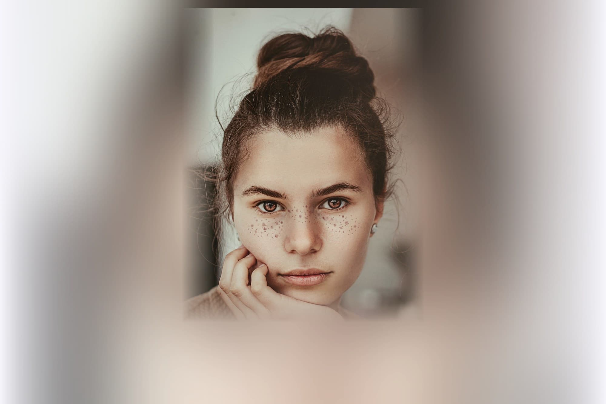 A woman resting a hand against her cheek